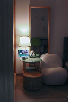 A comfortable bedroom setup featuring modern furniture, a lamp, and a tablet on a side table.