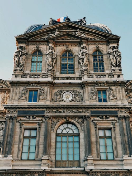 Free Close-up of Pavillon Sully's facade featuring sculptures and clock in Paris, France. Stock Photo