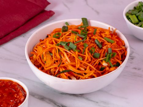 Delicious bowl of spicy noodles topped with fresh spring onions, perfect for Asian cuisine lovers.