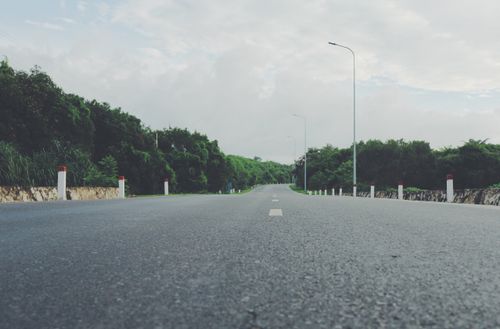 Free Wide open highway through lush green forest on a cloudy day, perfect for travel concepts. Stock Photo