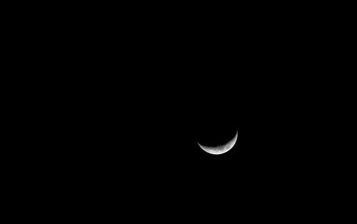 Free A serene capture of the crescent moon against a vast, dark night sky. Stock Photo