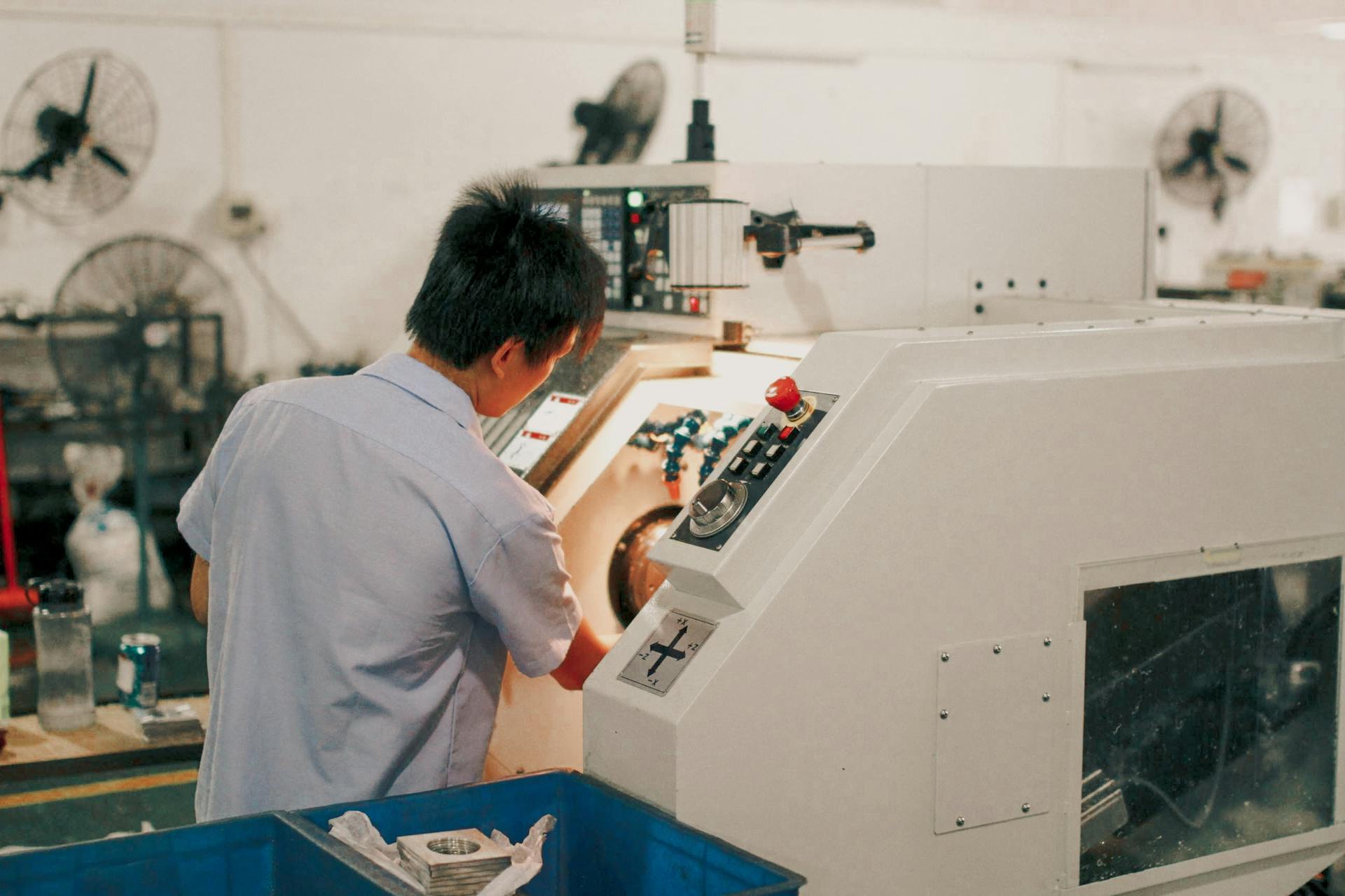 Worker focusing on operating industrial machinery in a factory setting.