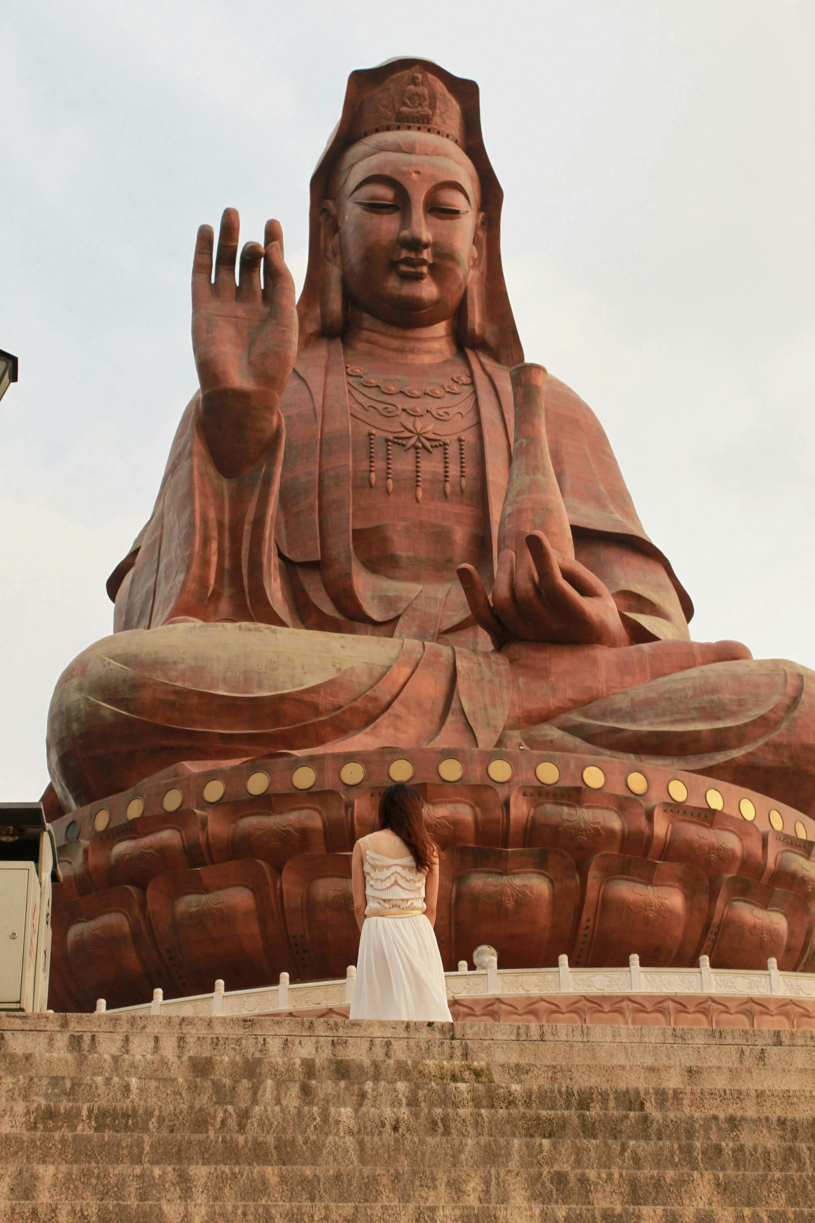 A Woman Fronting a Giant Guanyin Statue · Free Stock Photo