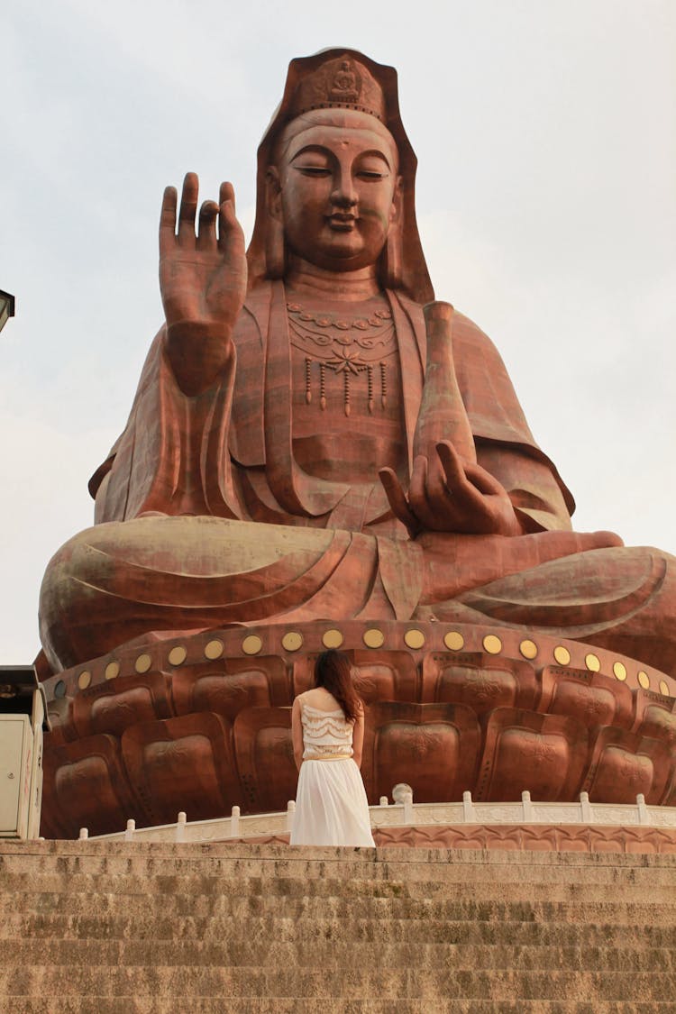 A Woman Fronting A Giant Guanyin Statue