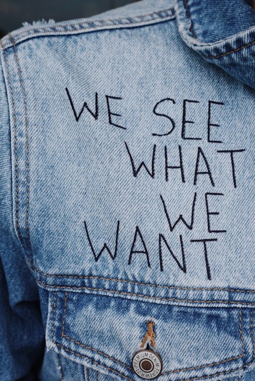 бесплатная синий джинсовый топ с воротником и накладным текстом We See What We Want Стоковое фото