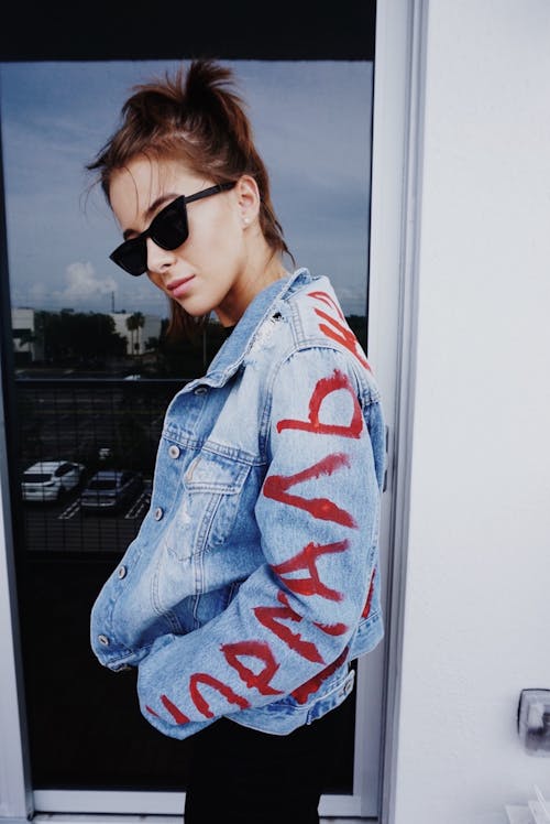 Free Woman in Painted Denim Jacket Wearing Black Sunglasses Stock Photo