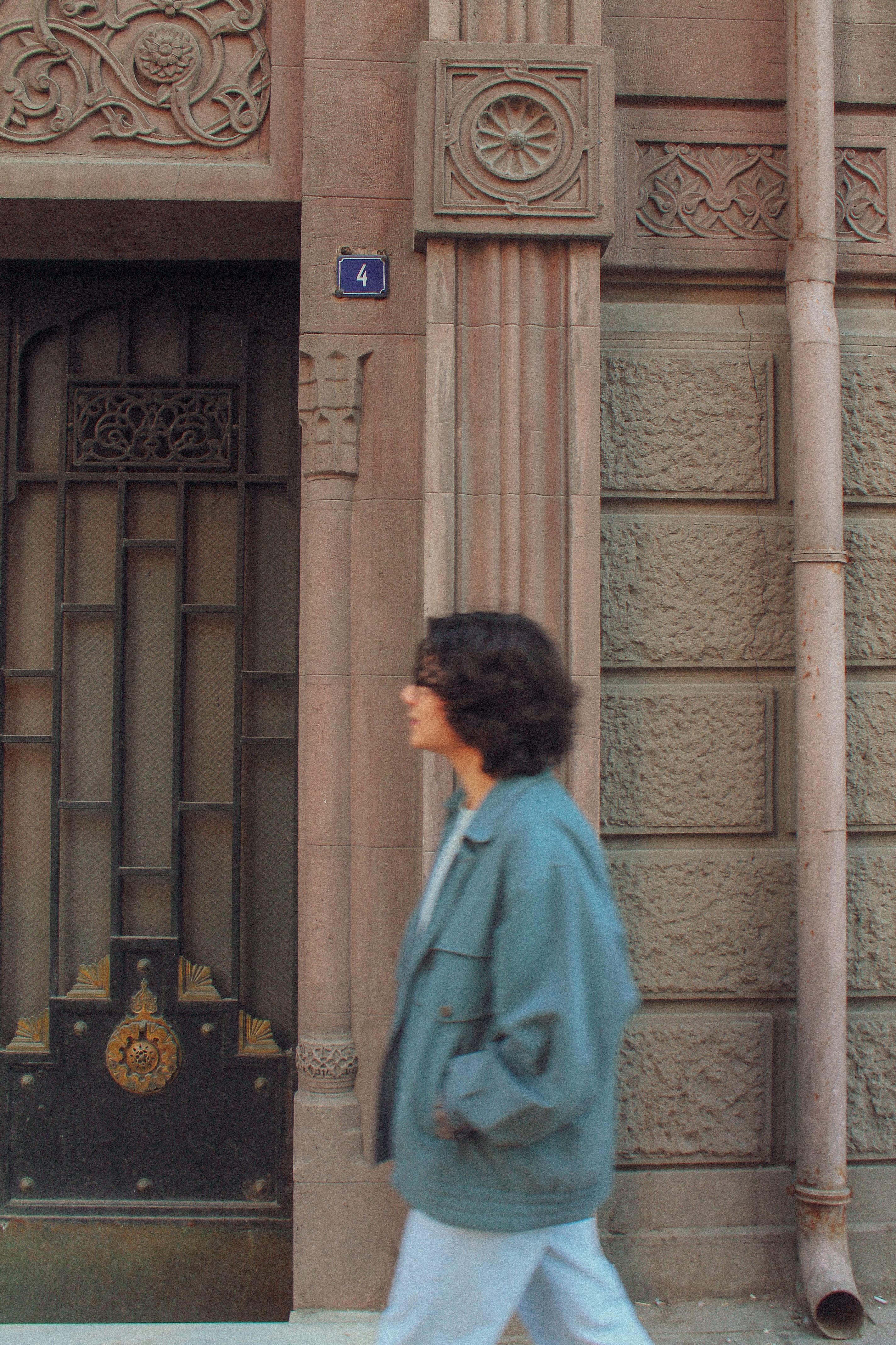 Brunette Woman Walking by a Decorative Townhouse · Free Stock Photo