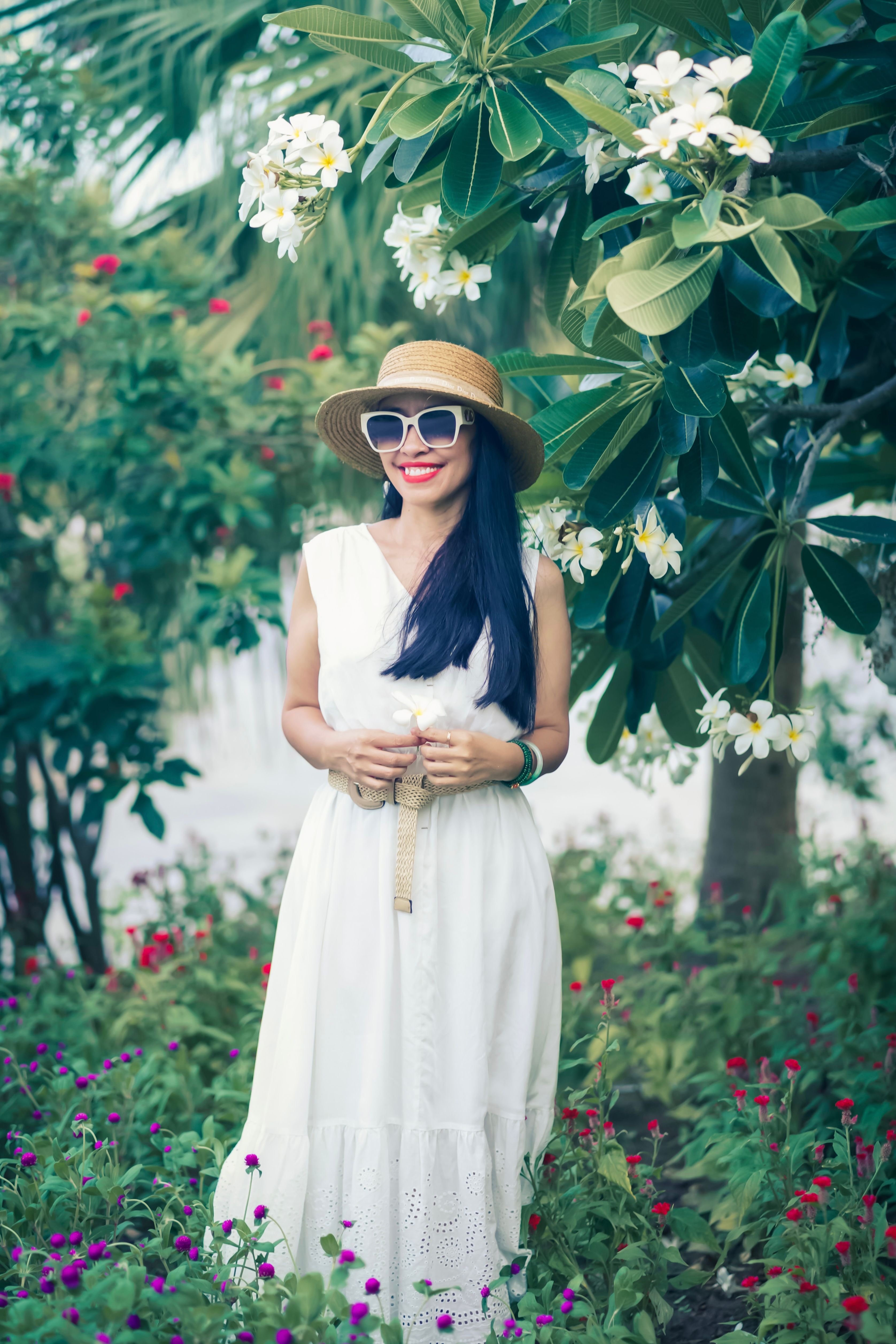 A Woman in Floral Print Dress Holding a Flower · Free Stock Photo