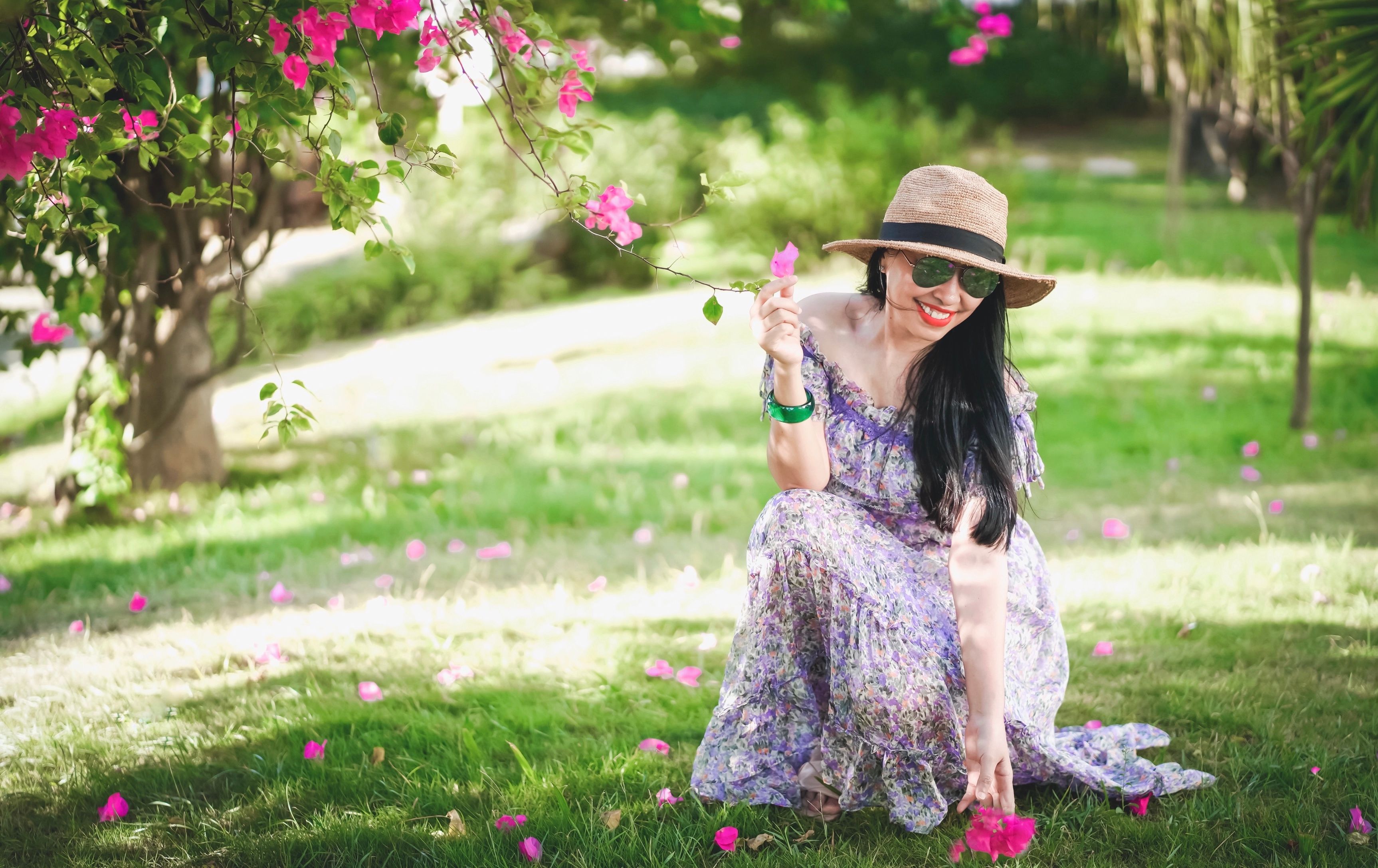 A Woman in Floral Print Dress Holding a Flower · Free Stock Photo
