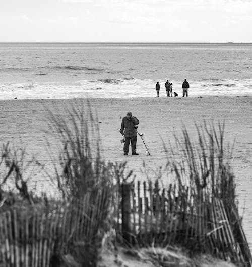 A Person Standing on Sand near the Beach