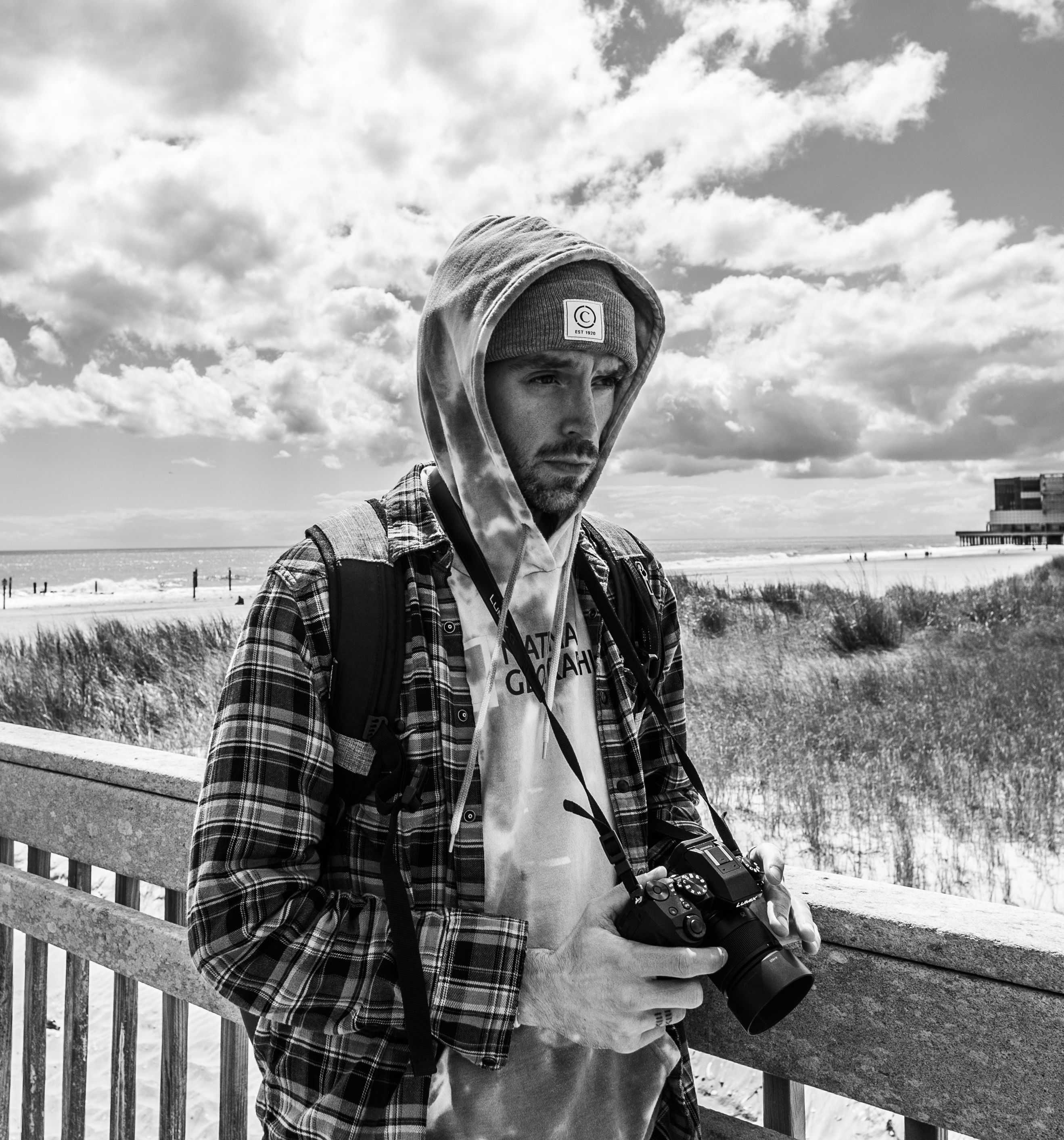 Stylish man with camera at Atlantic City boardwalk in monochrome