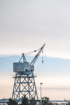 Large industrial crane towering with a backdrop of clear blue sky.