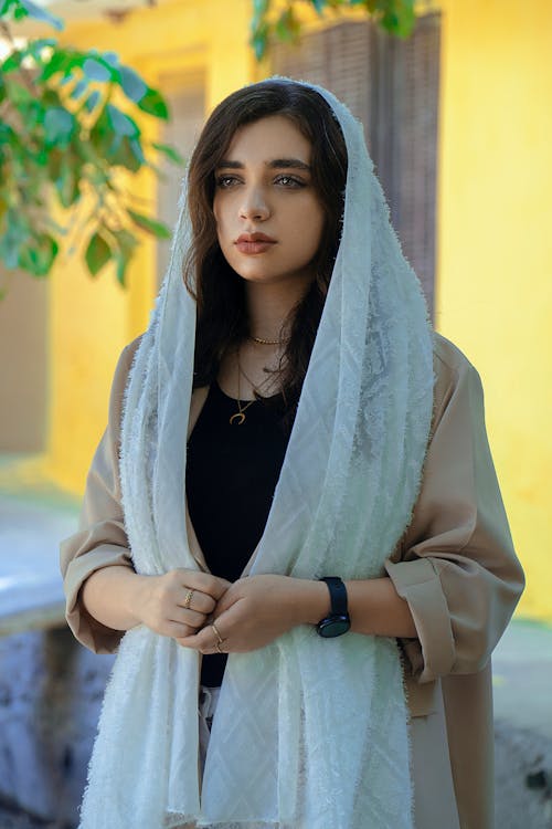 Beautiful Model in a White Lace Headscarf and a Beige Coat