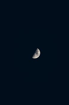 A stunning high contrast image of a half moon against a dark night sky.