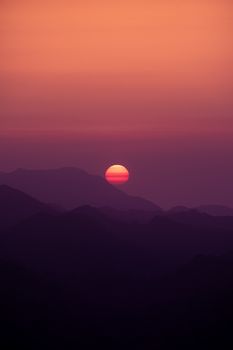 Captivating sunset over silhouette mountains with vibrant hues.