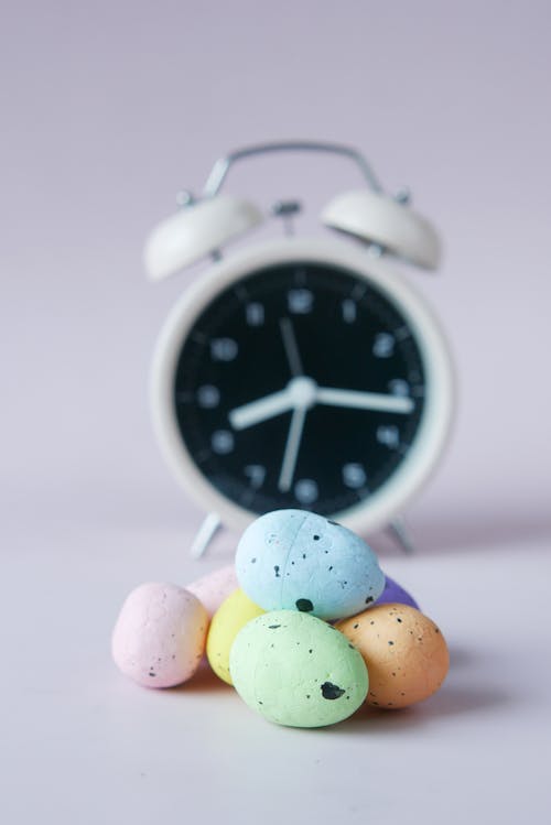 Free Easter Eggs Beside an Alarm Clock Stock Photo