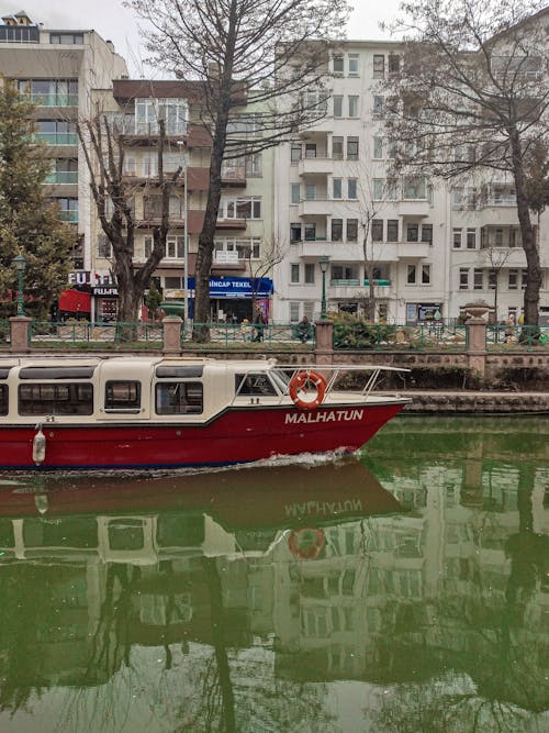 Red Boat on a Green Canal in a City