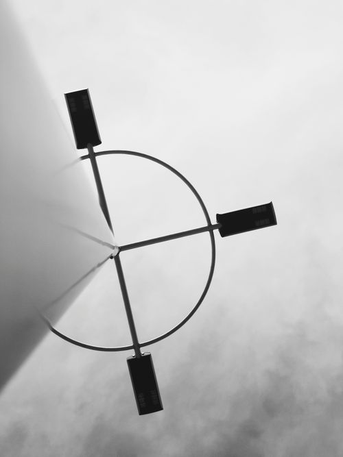 Free A minimalist perspective of a street light tower against a cloudy sky in black and white. Stock Photo