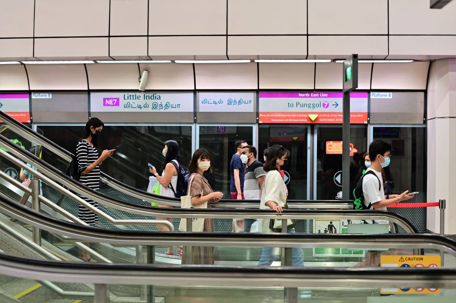 Masked commuters walking in Little India MRT Station, Singapore. Capturing daily transit life.