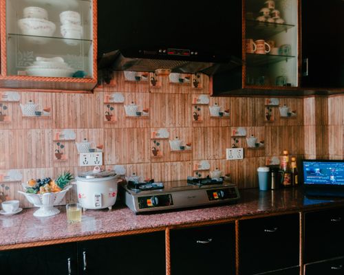 Free A cozy kitchen featuring a rice cooker, stove, and rustic wooden decor with glass cabinets. Stock Photo