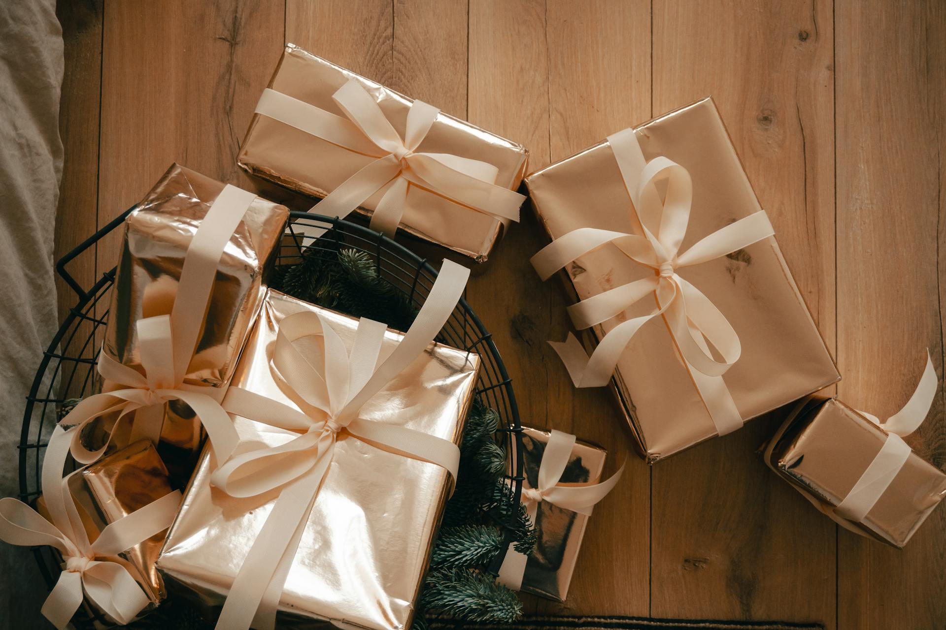 Top view of elegantly wrapped gift boxes with ribbons on wooden floor, perfect for holiday imagery.