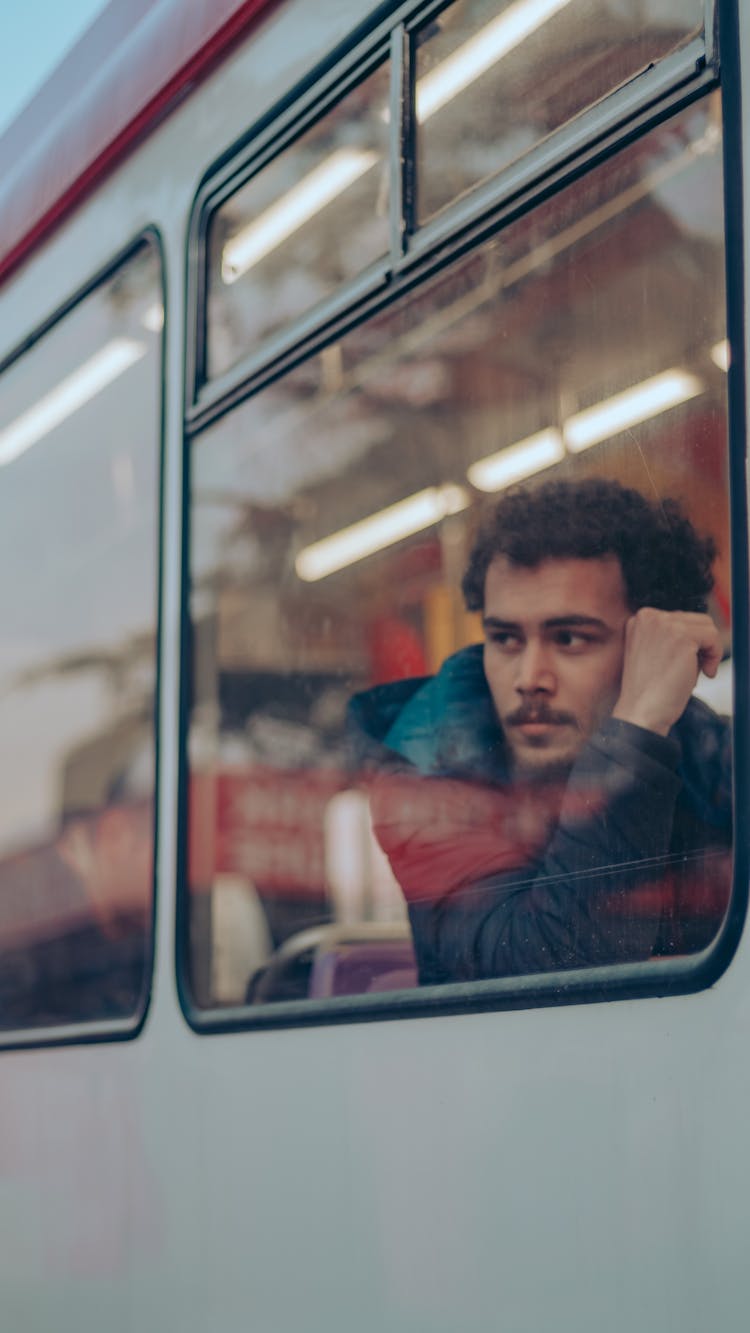 Man Looking Outside The Window Of A Train