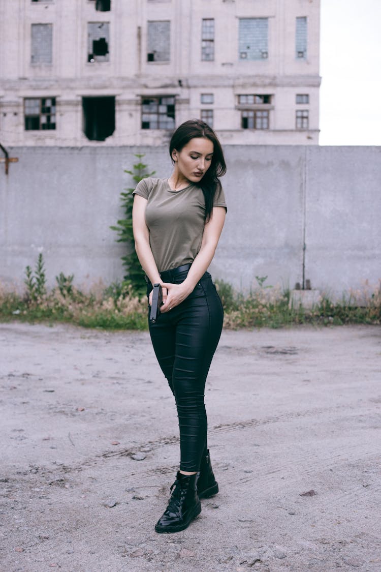 Woman Holding A Gun While Looking Down