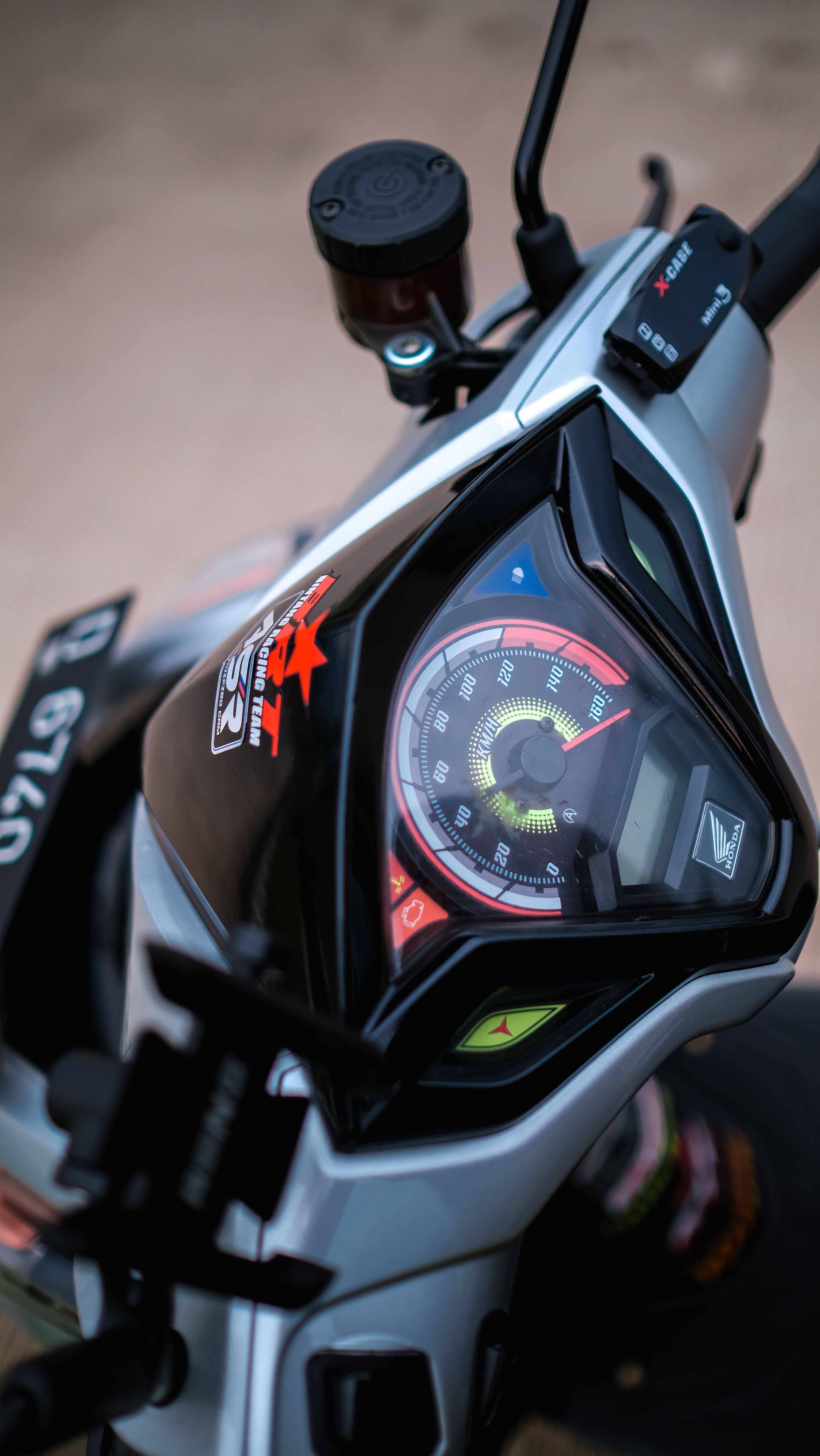 High-angle close-up of a motorcycle speedometer and handlebars.