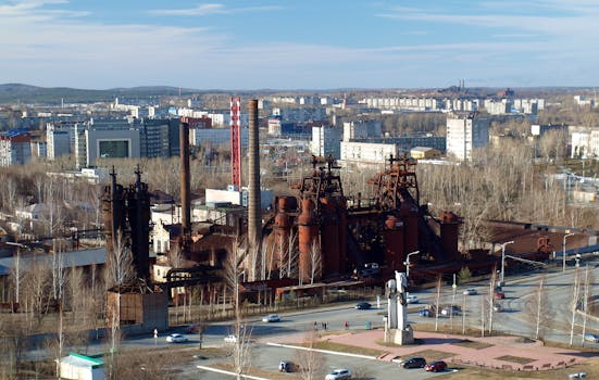 Aerial view capturing an old industrial plant with cityscape in the background.
