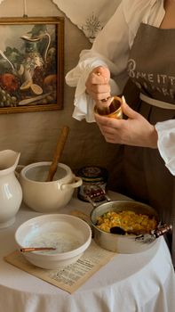 A person preparing food in a rustic kitchen setting with vintage decor.