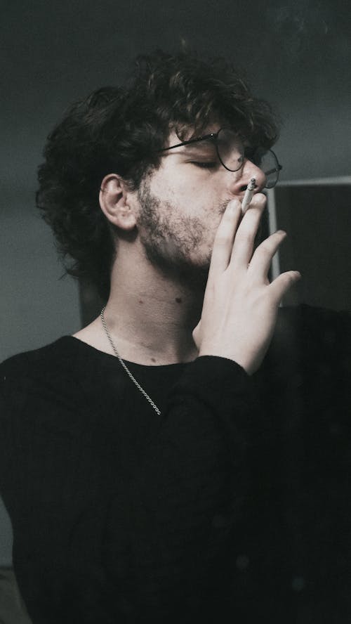 Man in Black Long Sleeve Shirt Smoking Cigarette