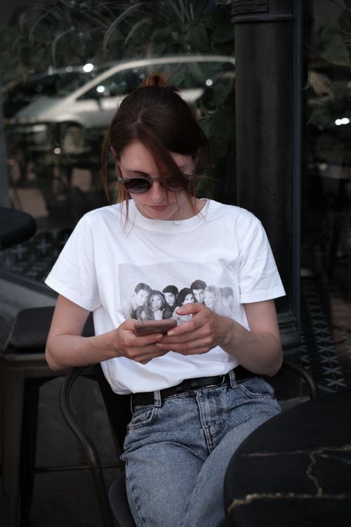 Free A young woman in sunglasses using phone outdoors in Odesa, Ukraine, offering a stylish and relaxed vibe. Stock Photo