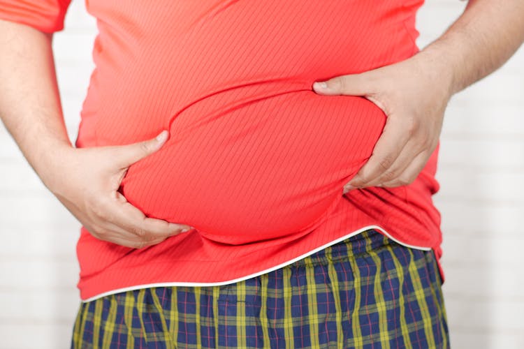 Close-up Photo Of Person Holding His Belly 