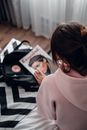 Woman in Pink Turtleneck Shirt Sitting on Black and White Checkered Textile