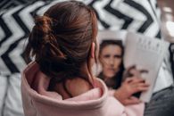 Woman in Pink Hoodie Lying on Bed