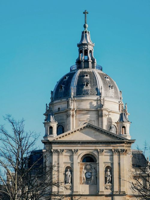 Free A beautiful classical church dome against a clear blue sky, showcasing exquisite sacral architecture. Stock Photo