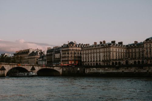 Free Charming view of historic buildings and bridge over the Seine River in Paris at dusk. Stock Photo