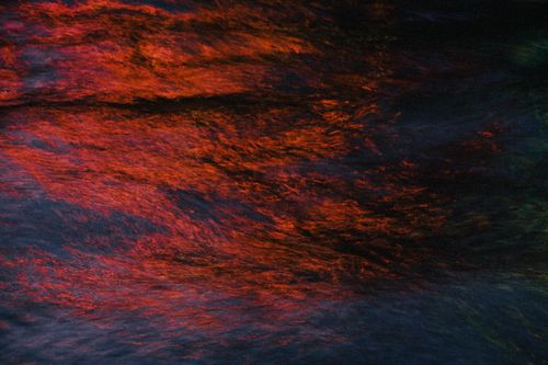 Free Vivid abstract patterns of red and blue light reflecting on water surface. Stock Photo