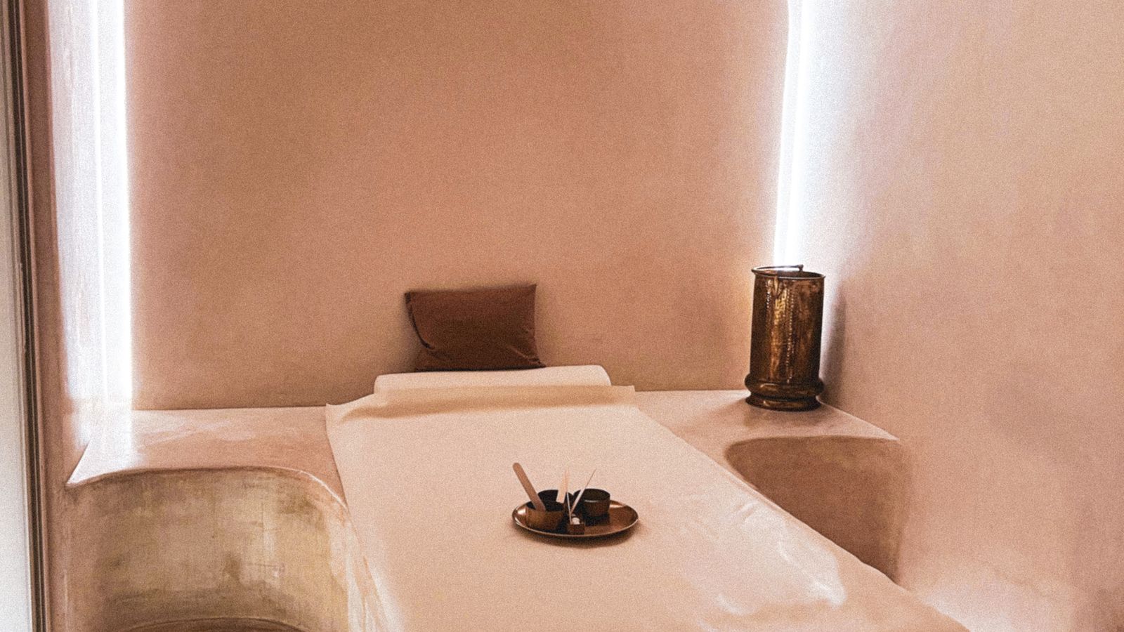 A prepared massage table in a softly lit spa room