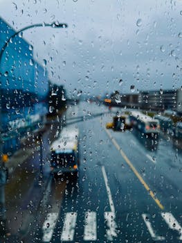 View of a rainy street in Halifax through a raindrop-covered window, creating a moody atmosphere.