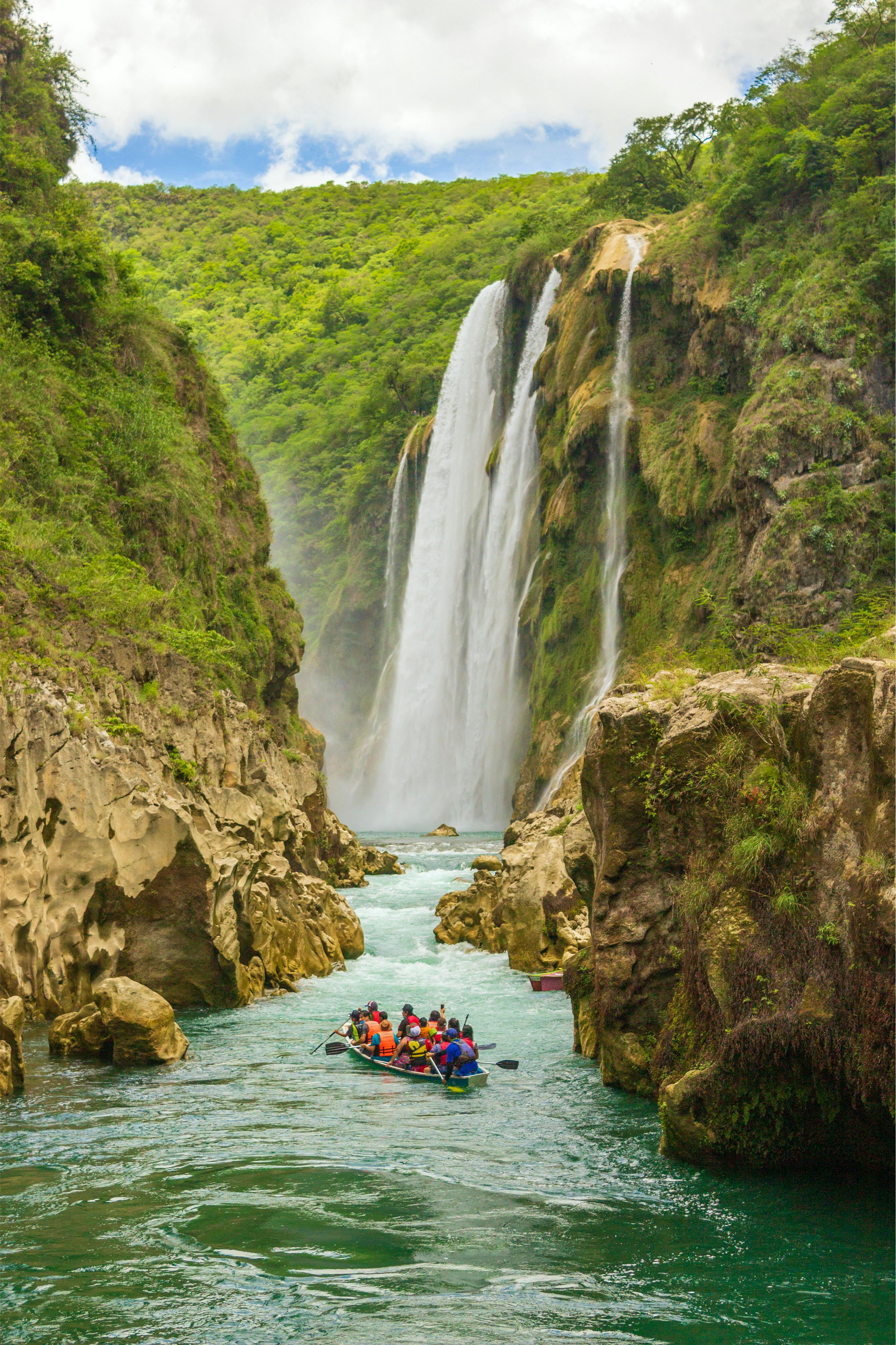 People Riding on Kayak on River Between Rocky Mountain