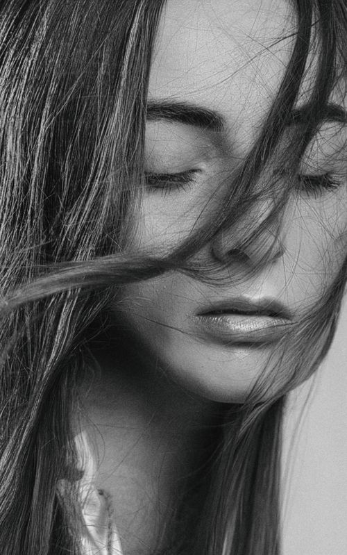 Free Dramatic black and white portrait of a woman with closed eyes and flowing hair. Stock Photo