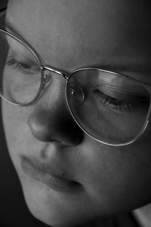 Free Intimate black and white portrait of a woman in glasses with eyes closed. Stock Photo