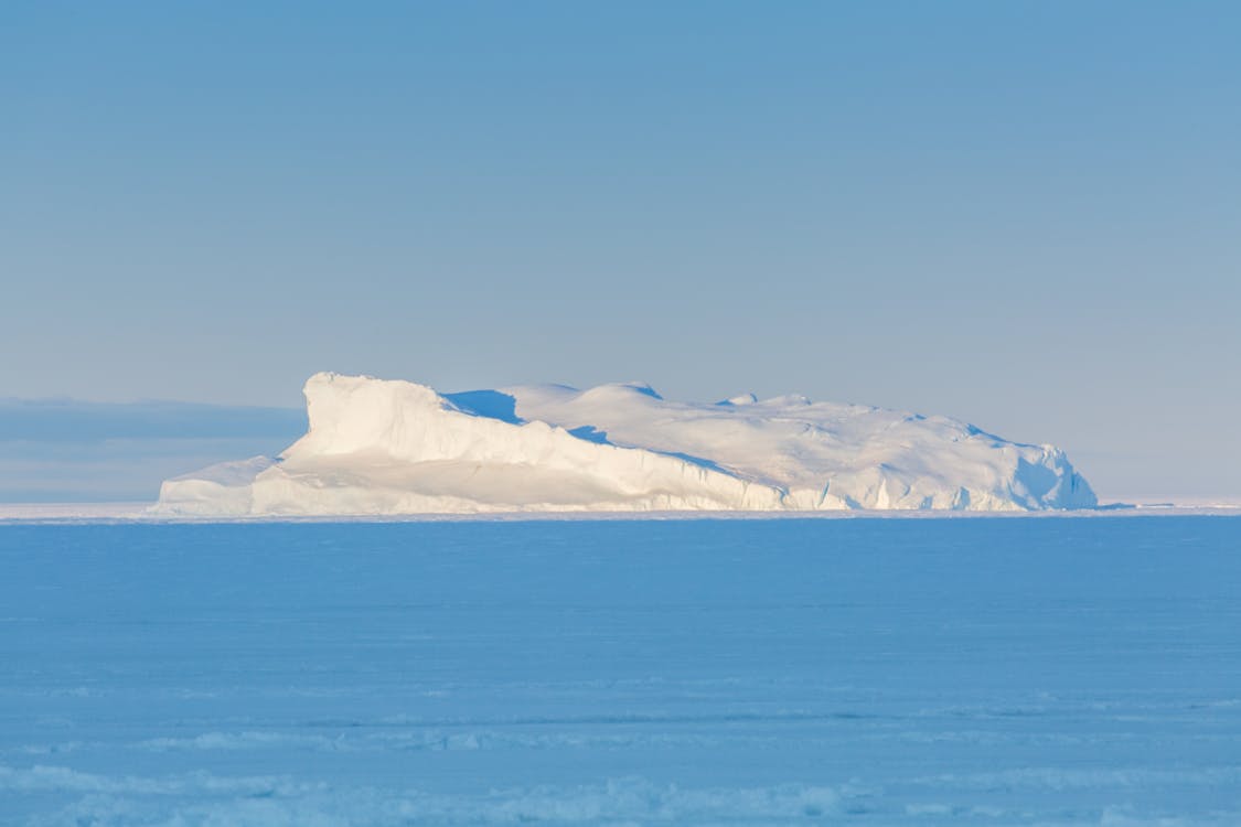 An Iceberg on the Ocean Under Blue Sky