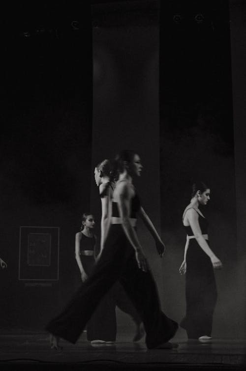 Monochrome Photo of Women walking pass each other 