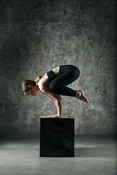 A woman balances skillfully on a block, showcasing her yoga prowess indoors.