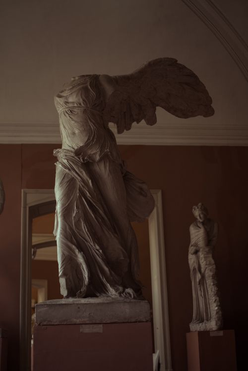 Free Elegant marble statue of Winged Victory of Samothrace in museum setting. Stock Photo