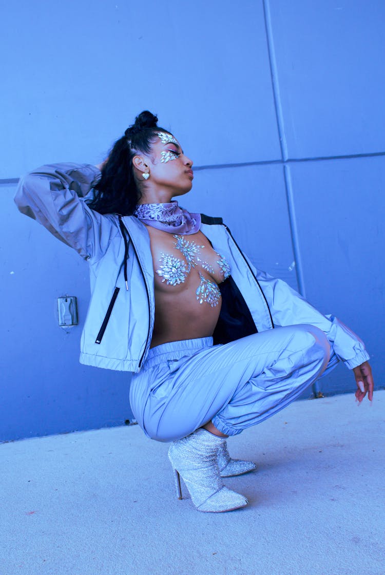 Woman Wearing Suit And Body Jewelry Crouching