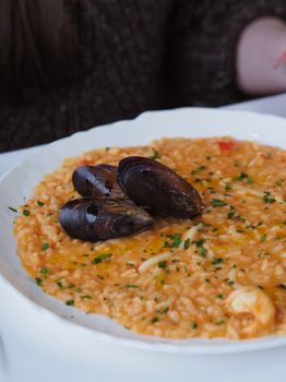 Savor a rich seafood risotto topped with fresh mussels, artfully plated and garnished.