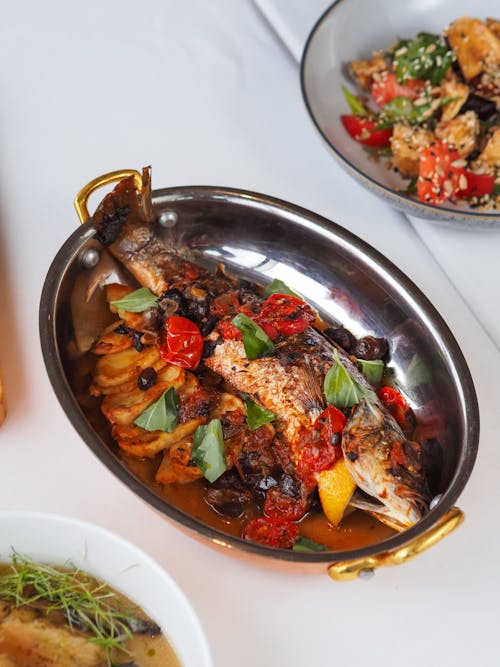 Free Gourmet grilled fish with roasted vegetables on a silver platter, ready to serve. Stock Photo